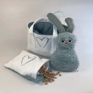 Geschenkset zur Geburt mit Kuscheltier, Kirschkernkissen und praktischer Stofftasche. Auf der Abbildung ist das Kirschkernkissen geöffnet und die Kirschkerne sind zu sehen