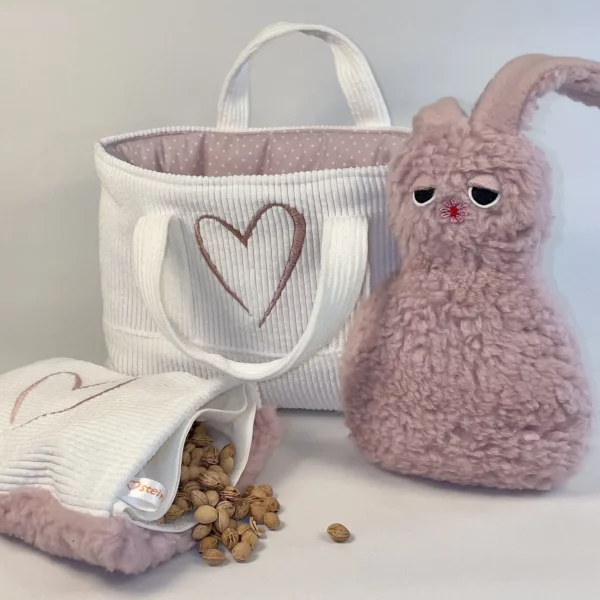 Geschenkset zur Taufe Mädchen mit Kuscheltier, Kirschkernkissen und praktischer Stofftasche. Auf der Abbildung ist das Kirschkernkissen geöffnet und die Kirschkerne sind zu sehen