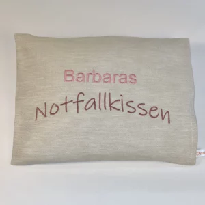 Traubenkernkissen Geschenk für Frauen mit Personalisierung. Auf das cremefärbige Traubenkernkissen wurde gut leserlich "Barbaras Notfallkissen" in Farben rosé und braun gestickt. Das handgemachte Wärmekissen mit Größe 20*25 cm ist waschbar. Die Kerne sind durch einen Klettverschluss im Innenkissen austauschbar.